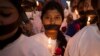 FILE - Indian women participate in a candle light vigil at a bus stop where the victim of a 2012 deadly gang rape had boarded the bus on what would become her final journey, in New Delhi, India, Dec. 16, 2014.