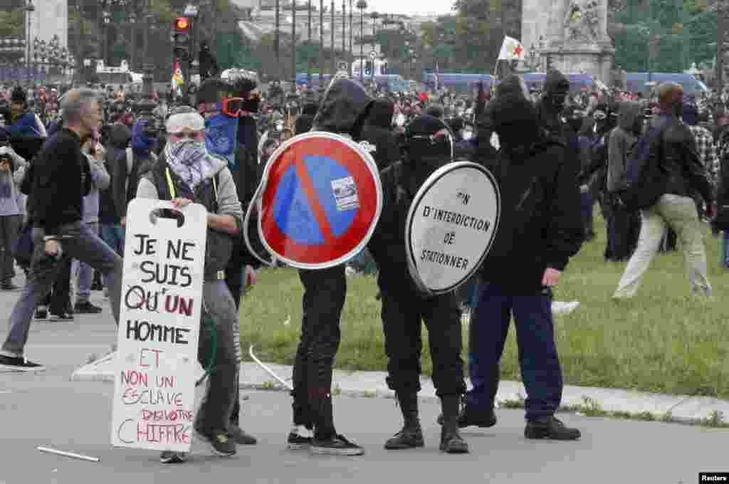 Para demonstran buruh Perancis yang memakai topeng terlibat bentrok dengan polisi anti huru-hara di Paris.