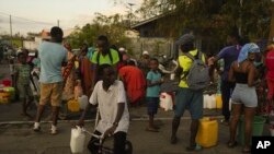 La gente hace fila para recolectar agua el miércoles 18 de diciembre de 2024 en la isla francesa de Mayotte, en el océano Índico.