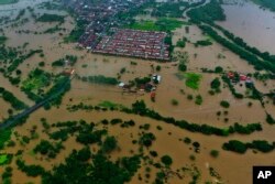 Air banjir menggenangi kota Itapetinga di wilayah selatan negara bagian Bahia, Brazil, Minggu, 26 Desember 2021. (Foto: AP)