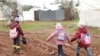 Internally displaced Syrian children walk in mud near tents at a camp in northern Aleppo near the Syrian-Turkish border.