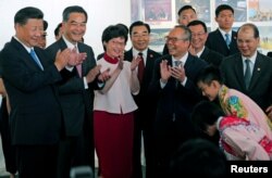 시진핑(왼쪽) 중국 국가주석이 29일 홍콩국제공항에 내린 직후 현지 어린이들의 인사를 받고있다. 마중나온 렁춘잉(왼쪽 두번째) 행정장관과 캐리 람(세번째) 행정장관 당선인 등이 함께 박수하고 있다.