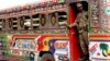 A Pakistani soldier stands guard in a bus carrying election staff and polling related material to stations in Karachi, Pakistan, July 24, 2018.