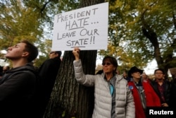 Un participante en la marcha en memoria de las víctimas del tiroteo de la sinagoga Árbol de la Vida, sostiene un cartel expresando su oposición al presidente de Estados Unidos Donald Trump, en Pittsburgh, Pensilvania, el 30 de octubre de 2018. Reuters.