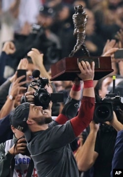 Steve Pearce de los Medias Rojas de Boston sostiene el trofeo de MVP después del Juego 5 de la Serie Mundial de béisbol contra los Dodgers de Los Angeles el domingo, 28 de octubre de 2018, en Los Ángeles. Los Medias Rojas ganaron 5-1 para ganar el juego de la serie 4 a 1. (AP Photo / Mark J. Terrill).