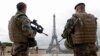 FILE - French army paratroopers patrol near the Eiffel tower in Paris, France, March 30, 2016. Conducting an inquiry into last year's Paris attacks, a French parliamentary committee on Tuesday released 39 recommendations, including streamlined intelligence gathering.