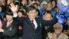 Nago City Mayor Susumu Inamine (C), flanked by his wife Ritsuko, celebrates after he was re-elected in the mayoral election in Nago, on the Japanese southern island of Okinawa, Jan. 19, 2014. 