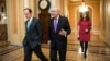 Senate Majority Leader Mitch McConnell, center, walks with Sen. Pat Toomey to the chamber for the vote to impose more stringent sanctions on North Korea, Feb 10, 2016.