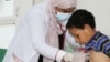 FILE - Nahla Arishi, a pediatrician, checks a boy infected with diphtheria at the al-Sadaqa teaching hospital in the southern port city of Aden, Yemen, Dec. 18, 2017. 