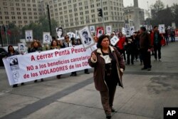 En esta foto del 12 de agosto de 2016, Lorena Pizarro, presidenta de una asociación de familiares de detenidos desaparecidos durante la dictadura del general Augusto Pinochet, encabeza una protesta para exigir el cierre de la cárcel de Punta Peuco frente al palacio presidencial La Moneda en Santiago, Chile. Foto: AP/Esteban Félix.