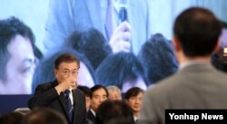 문재인 한국 대통령이 17일 청와대에서 개최한 취임 100일 회견 도중 일본 기자가 질문하는 동안 물을 마시고 있다.