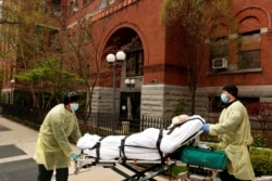 Los técnicos de emergencias médicas (EMT) sacan a un hombre del hogar de ancianos Cobble Hill Health Center durante un brote de coronavirus.