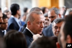 Turkey's President Recep Tayyip Erdogan, talks to MPs of his ruling Justice and Development Party (AKP) after delivering a speech at the parliament in Ankara, Turkey, Tuesday, Nov. 20, 2018.