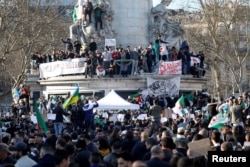 FILE - Demonstrators gather around the Monument to the Republic during a protest against President Abdelaziz Bouteflika seeking a fifth term in a presidential election set for April 18, in Paris, France, Feb. 14, 2019.