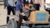 Un niño palestino se sienta junto a una caja de ayuda proporcionada por la UNRWA fuera de un punto de distribución, en medio de un alto el fuego entre Israel y Hamás, en Khan Younis, en el sur de la Franja de Gaza, el 4 de febrero de 2025.