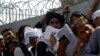 Afghan nationals carry their passports as they wait to extend their visas outside the Pakistani immigration office in Peshawar on March 13, 2017, following the Pakistani Torkham and Chaman borders were closed with Afghanistan. A spike in tensions led to t