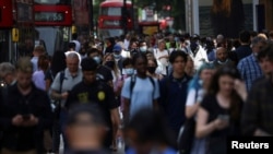 FILE PHOTO: People walk along Oxford Street, amid the coronavirus disease (COVID-19) outbreak, in London, Britain, July 26, 2021. 