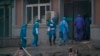 Hospital staff wash the emergency entrance of Wuhan Medical Treatment Center, where some infected with a new virus are being treated, in Wuhan, China, Wednesday, Jan. 22, 2020.