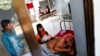 FILE - A malaria patient is comforted in the only hospital in Pailin, Cambodia.