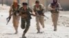 FILE - Kurdish fighters from the People's Protection Units (YPG) run across a street in Raqqa, Syria, July 3, 2017. 