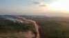 En esta vista aérea, el polvo rojo de la carretera BR230, conocida como "Transamazónica", se mezcla con incendios al atardecer en la localidad agrícola de Ruropolis, estado de Pará, norte de Brasil, el 6 de septiembre de 2019.