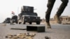 An Iraqi special forces soldier runs as other drive in armored vehicles on a road near Mosul, Iraq, Oct. 25. 2016.