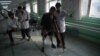 FILE - An Afghan doctor, right, assists a survivor of a land mine blast at a hospital run by the International Committee of the Red Cross for war victims and the disabled in Kabul, Feb. 13, 2018. The Taliban announced Oct. 11, 2018, that it would allow the ICRC to fully resume operations in Afghanistan.