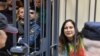 Russian artist Sasha Skochilenko, accused of spreading disinformation about the Russian army for swapping supermarket price tags with messages criticizing the invasion of Ukraine, sits in a defendant's cage during her verdict hearing in St. Petersburg on Nov. 16, 2023.