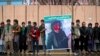 Afghan men stand in front of the supreme court during a protest demanding justice for a woman who was beaten to death by a mob after being falsely accused of burning a Quran last week, in downtown Kabul, Afghanistan, Tuesday, March 24, 2015.