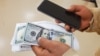 Un inmigrante centroamericano muestra el dinero a depositar en su sitio de envío de remesas en las afueras de Washington DC. 