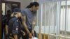 La estrella de la WNBA y dos veces medallista de oro olímpica Brittney Griner, a la derecha, ingresa a una celda en un tribunal antes de una audiencia en Khimki, en las afueras de Moscú, Rusia, el jueves 4 de agosto de 2022.