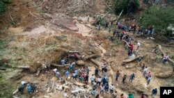 Rescatistas, residentes y voluntarios buscan víctimas después de un deslizamiento de tierra causado por fuertes lluvias en la ciudad costera de Guarujá, Brasil, el miércoles 4 de marzo de 2020.