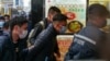 ARCHIVO - El editor jefe de Stand News, Patrick Lam (centro), es llevado esposado al edificio del medio de comunicación después de que la policía fuera desplegada para registrar las instalaciones en el distrito Kwun Tong de Hong Kong el 29 de diciembre de 2021.