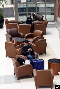 Pasajeros de aerolíneas esperan aviso sobre sus vuelos demorados en el aeropuerto internacional Albany en Colonie, N.Y., el domingo 20 de enero de 2019.