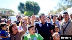Al otro lado de la frontera esperaban a los estudiantes decenas de inmigrantes que protestaban contra las deportaciones.