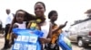 A woman carrying a baby holds a treated mosquito net during a malaria prevention action in Nigeria, April 21, 2016. WHO is providing anti-malaria drugs to children in northeast Nigeria in an effort to combat the disease.