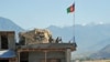 FILE - Two Afghan soldiers sit on a guard tower at a military base in Kunar province, Afghanistan, June 1, 2013.