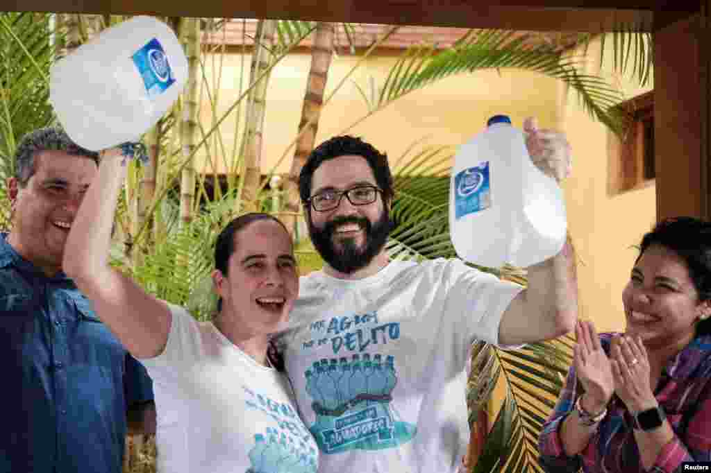 Margarita Hurtado Chamorro y Jesús Tefel Amador, miembros del movimiento opositor Unidad Nacional Azul y Blanco (UNAB), sostienen jarras de agua después de salir de prisión, en Managua, Nicaragua, el 30 de diciembre de 2019. (Foto de Reuters)