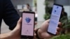 Government Technology Agency staff demonstrate Singapore's new contact-tracing smarthphone app called TraceTogether, as a preventive measure against the coronavirus in Singapore on March 20, 2020. 