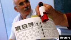 A person holds a ballot paper at a polling station during a mayoral election re-run in Istanbul, Turkey, June 23, 2019.