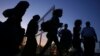 FILE - Migrants from Syria walk into a refugee camp in Kokkinotrimithia village outside the capital Nicosia, Cyprus.