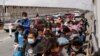 Migrantes de Centroamérica en busca de asilo, que fueron transportados en avión desde Brownsville a El Paso, Texas, y deportados de Estados Unidos, cruzan el puente fronterizo internacional Paso del Norte, Ciudad Juárez, México, el 22 de marzo de 2021.