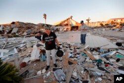 Lavonia Fortner ayuda a su suegro, John E. Fortner, a buscar recuerdos de su esposa, después del huracán Michael en Mexico Beach, Florida, el sábado 13 de octubre de 2018.