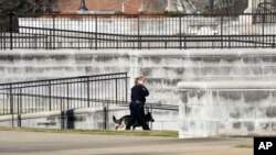 Una mujer policía inspecciona con un perro el exterior del el edificio de Justicia de Jackson, Mississippi, después de una amenaza de bomba el 4 de enero de 2024.