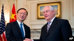 El secretario de Estado de EE.UU., Rex Tillerson, estrecha la mano con el diplomático de Estado chino, Yang Jiechi en el Departamento de Estado en Washington, el martes 28 de febrero de 2017.