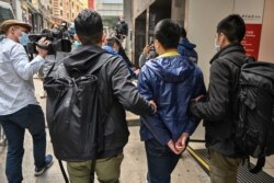 Ben Chung, 2nd right, of a pro-democracy political group is arrested by police in the Central district after as many as 50 Hong Kong opposition figures were arrested in Hong Kong, Jan. 6, 2021.