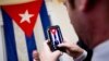 A visitor poses for a photograph in front of the last Cuban flag that was lowered from the Cuban Embassy in Washington on Jan. 3, 1961, when relations between the United States and Cuba were severed, in their new embassy in Washington, July 20, 2015.
