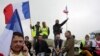 Demonstrators hold French flags as truckers block the highway near Calais, northern France, Sept. 5, 2016. 