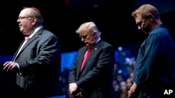 Desde la izquierda, el rabino Benjamin Sendrow acompañado por el presidente Donald Trump y el pastor Thom O'Leary, oran en la Convención y Exposición Agricultores del Futuro en Bankers Life Fieldhouse en Indianapolis, el 27 de octubre de 2018.