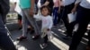 Migrant families from Mexico, fleeing violence, enter the United States to meet officers of the U.S. Customs and Border Protection to apply for asylum at Paso del Norte international border crossing bridge in Ciudad Juarez, June 20, 2018.